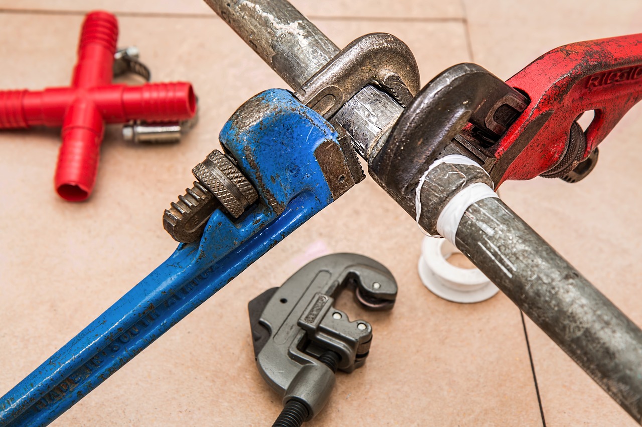 Professional plumber using a wrench to repair pipes, providing reliable plumbing services for efficient home maintenance and repairs